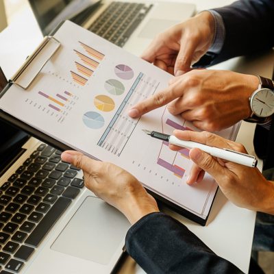 Business concept. Business people discussing the charts and graphs showing the results of their successful teamwork. Selective focus.